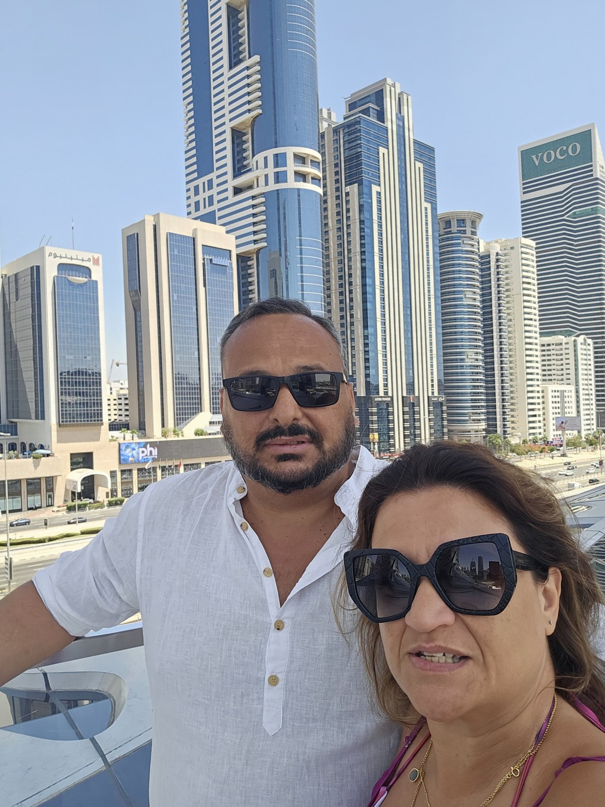 Marilene e Hugo com edifícios modernos do Dubai ao fundo